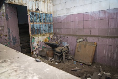 Téléchargez les photos : Vieille salle de ruine couverte de poussière avec chaise cassée dans un bâtiment abandonné désolé - en image libre de droit
