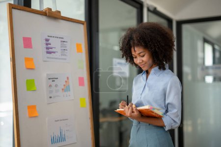 Photo for Businesswoman smile and writing plan on notebook business. Planning Strategy Analysis. Study the marketing plan for better planning. - Royalty Free Image