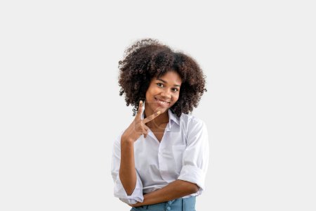 Téléchargez les photos : Une jeune femme noire souriante lève deux doigts. isolé sur un fond blanc. deux signes, Émotion humaine positive. - en image libre de droit