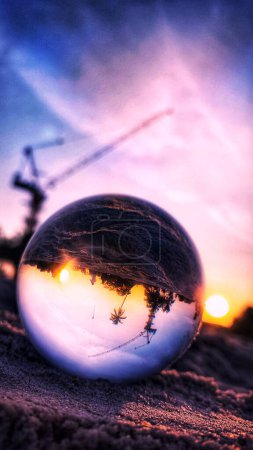 Photo for Capturing Crane Construction on the Beach Through the Lens of a Crystal Ball - Royalty Free Image