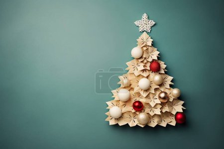 Handcraft composition of origami colored balls and a Christmas tree cut out of beige cardboard with copy space. Flat lay