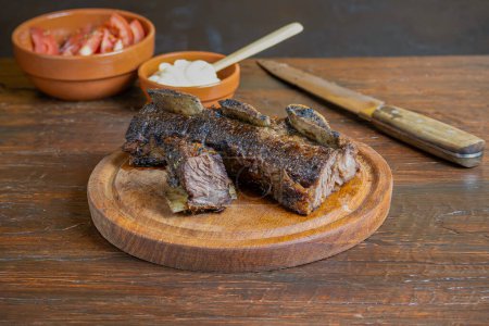 Photo for Cut of meat ribs cooked over embers on a grill, traditional Argentine food. - Royalty Free Image
