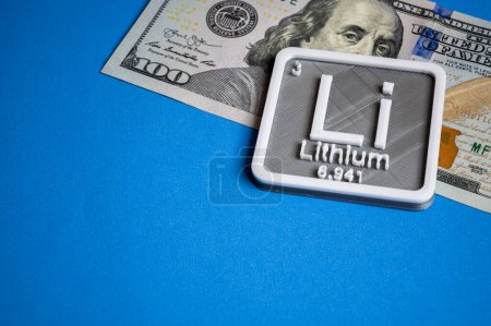 Téléchargez les photos : Concept lithium avec un billet de cent dollars sur fond bleu clair. - en image libre de droit