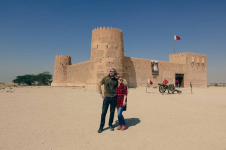 Foto de Pareja feliz cerca del fuerte de Al Zubara, histórica fortaleza militar qatarí, en la antigua ciudad de Zubarah, Qatar - Imagen libre de derechos