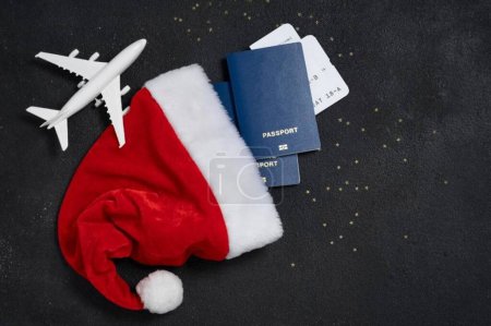 Photo for Santa Hat, Passports, Boarding Pass and Toy Airplane Flatlay - Royalty Free Image