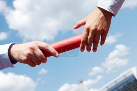 Photo of business people hands passing baton during marathon