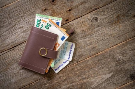 Téléchargez les photos : Cash et carte d'embarquement dans un portefeuille - en image libre de droit