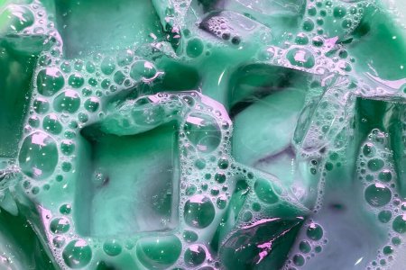 Photo for Colorful soapy liquid with bubbles closeup, cloudy water texture with transparent ice cubes and bubbles - Royalty Free Image