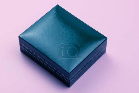 Luxus-Geschenkbox aus blauem Leder auf lila Hintergrund. Minimaler Stil.