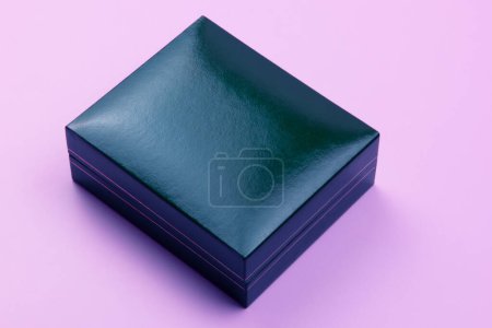 Boîte en cuir bleu isolé sur fond violet. Couché plat, vue du dessus.