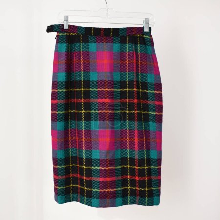 Photo for Scottish tartan skirt hanging on clothes hanger on white background - Royalty Free Image
