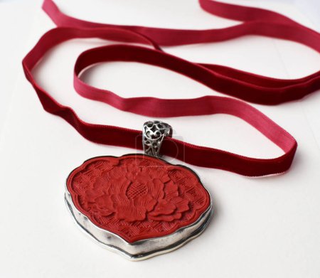 Red ribbon and heart-shaped gift box on a white background.