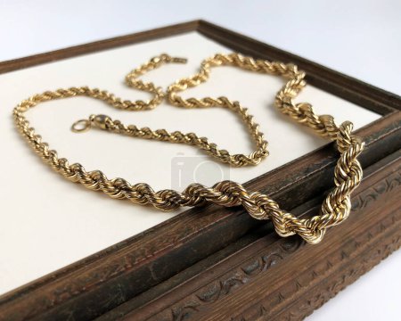 golden necklace in a wooden box on a white background close up