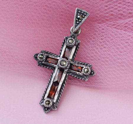 jewelry cross on a pink background, closeup of photo