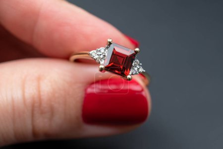 Wedding ring with red gemstone on a black background.