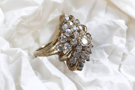 Téléchargez les photos : Vieil anneau en or avec pierres précieuses sur fond beige, bijoux vintage pour femme - en image libre de droit
