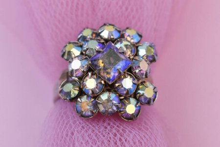 jewelry ring with precious stones on a pink background close up
