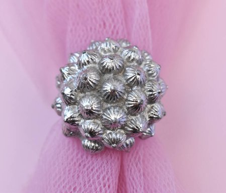 Silver christmas ball on pink tulle background close up macro photo