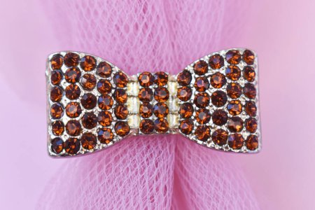 Beaded bow tie on pink background. Fashionable concept.