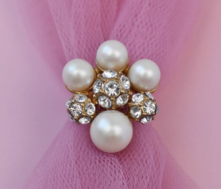Téléchargez les photos : Broche bijoux avec perles sur fond de tissu rose - en image libre de droit
