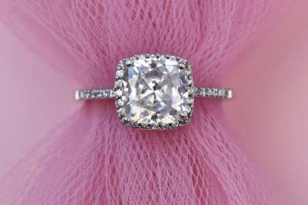 Jewelry diamond ring on a pink background close-up.