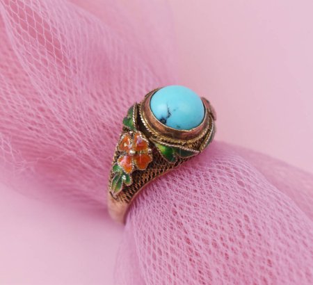 Jewelry ring with turquoise gemstone on pink background