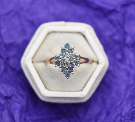 jewelry brooch with precious stones on purple background close up