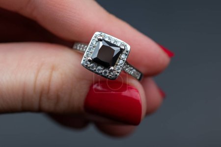 Jewelry ring in female hand on a dark background close up