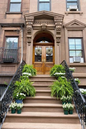 Puerta de madera con flores en las escaleras de la ciudad de Nueva York.