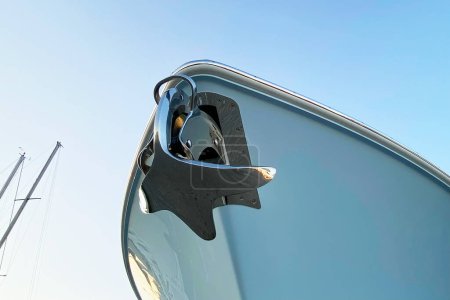 Detail of the hull of a yacht against the blue sky.