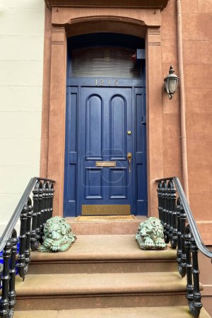 Old blue wooden door and stairs in New York City, USA.