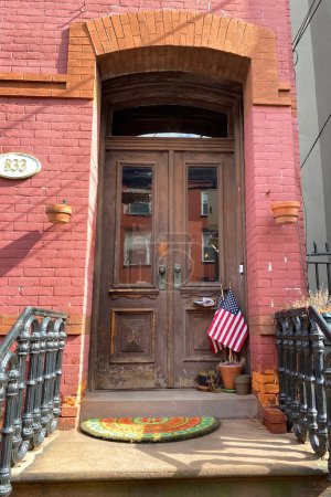 Old wooden door with a flag in New York City, USA.