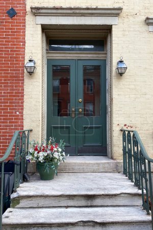 Front door of a house in New York City, USA. The front door is decorated with flowers.