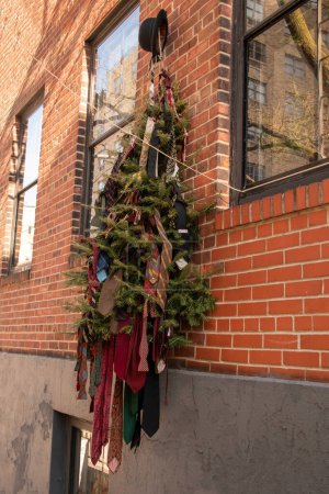 Weihnachtskränze hängen an der Wand eines Backsteingebäudes.