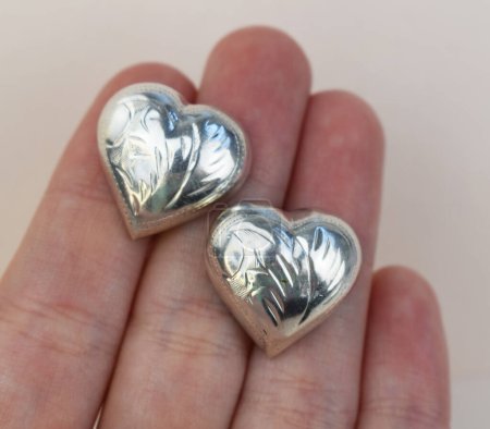 Foto de Dos corazones de plata en la mano sobre un fondo claro. Día de San Valentín - Imagen libre de derechos