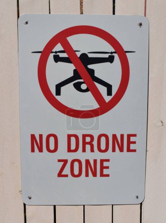 Téléchargez les photos : Pas de panneau de zone de drone sur un mur en bois avec un drone en arrière-plan - en image libre de droit