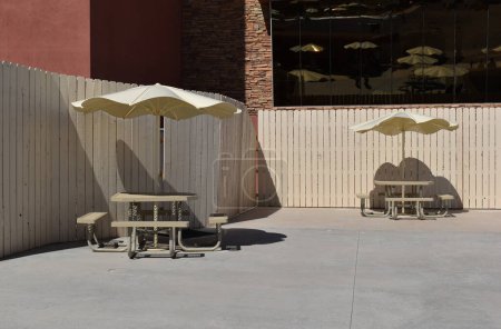 Café im Freien mit Stühlen und Sonnenschirmen an einem sonnigen Tag