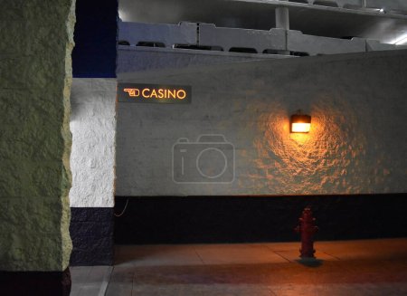 Weiße Wand der Tiefgarage mit beleuchtetem Casino-Schild