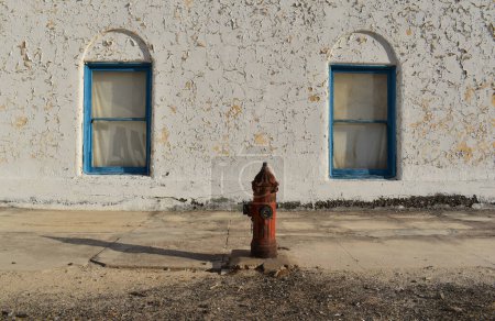 Téléchargez les photos : Ancienne bouche d'incendie sur le fond d'un mur blanc et fenêtres bleues - en image libre de droit