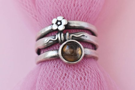 Jewelry ring with gemstone on pink background. Macro.