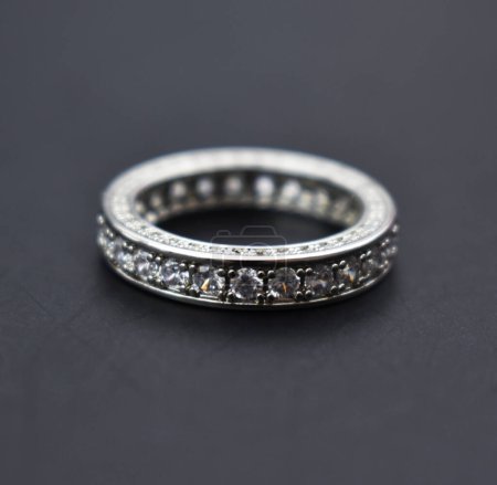 Wedding ring with diamonds on a dark background closeup.