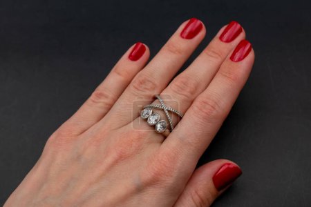 Téléchargez les photos : Bague en diamant sur une main féminine sur un fond noir, gros plan - en image libre de droit