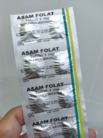 Téléchargez les photos : Jakarta, 19 décembre 2023 : Un pharmacien tient une bandelette d'acide folique ou d'asam folat - en image libre de droit