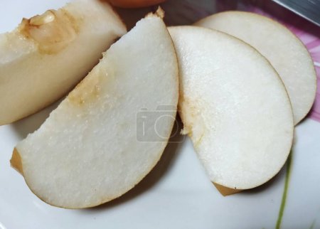 Téléchargez les photos : Tranches de poire singo sur une assiette blanche - en image libre de droit