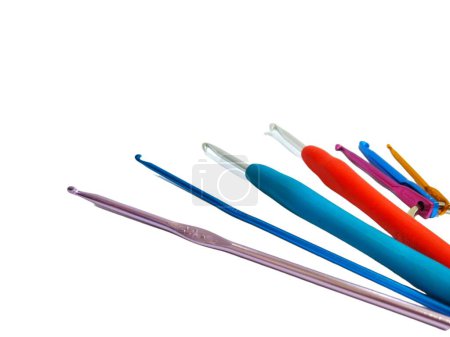Many kind of colored crochet hooks on white background