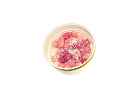 Kleine Blütenform rosa Perlen auf Schale, isoliert auf weißem Hintergrund