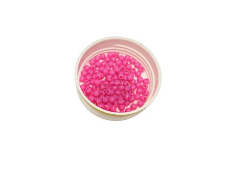 Small fuchsia beads on bowl, isolated on white background