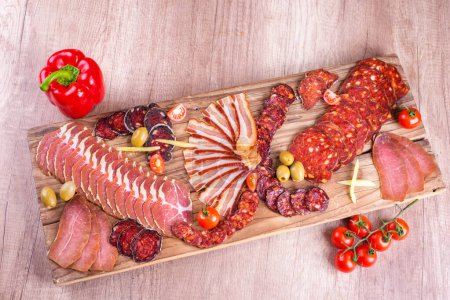 Wooden plate, smoked meat arrangement, above view