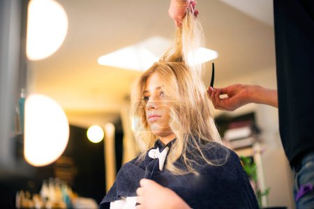 Téléchargez les photos : Jeune fille blonde chez le coiffeur, nouveau style - en image libre de droit