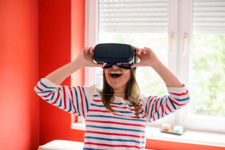 Mujer joven disfrutando de usar VR googles en casa